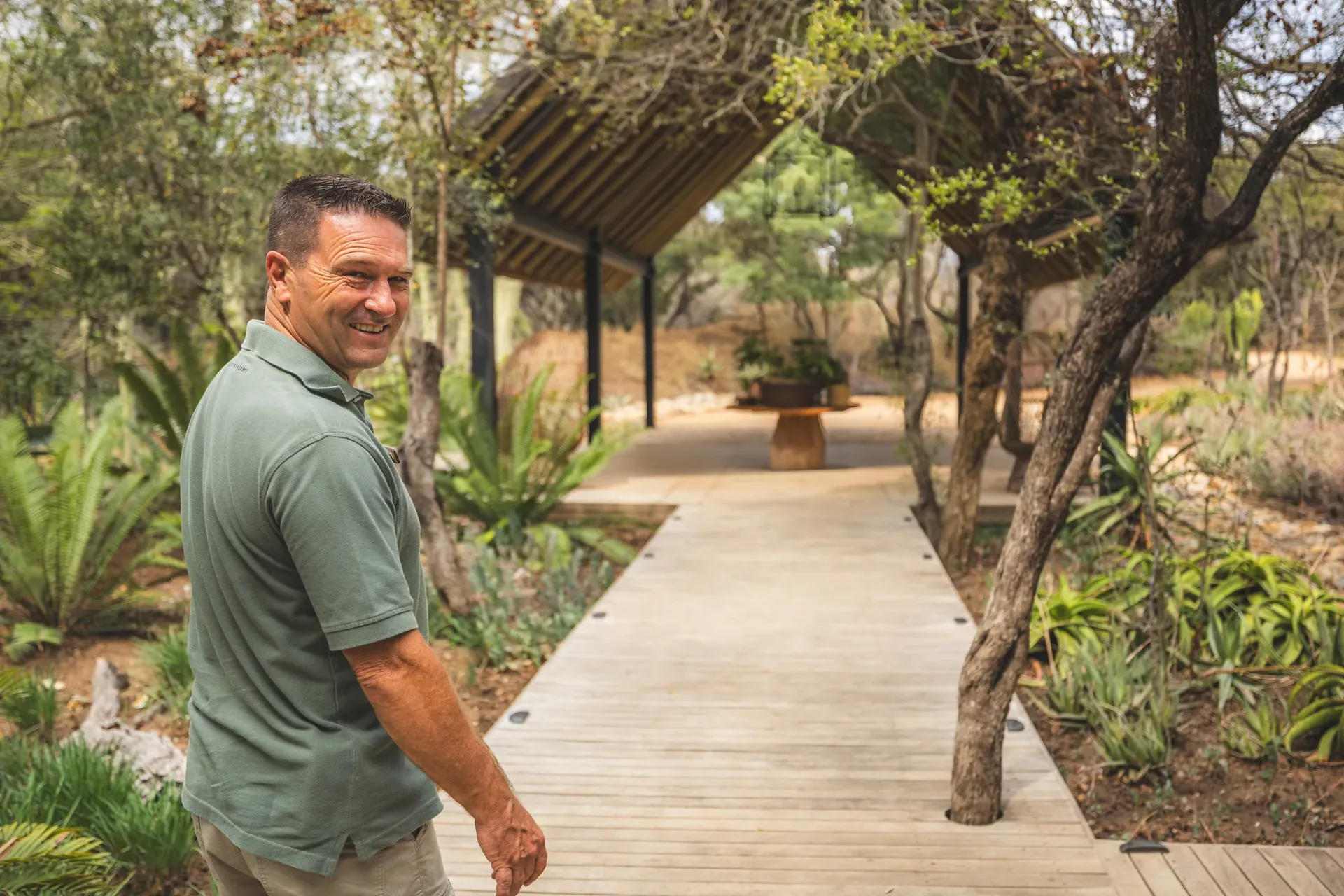 Guest walking into Monwana Lodge with the garden visible in the background.