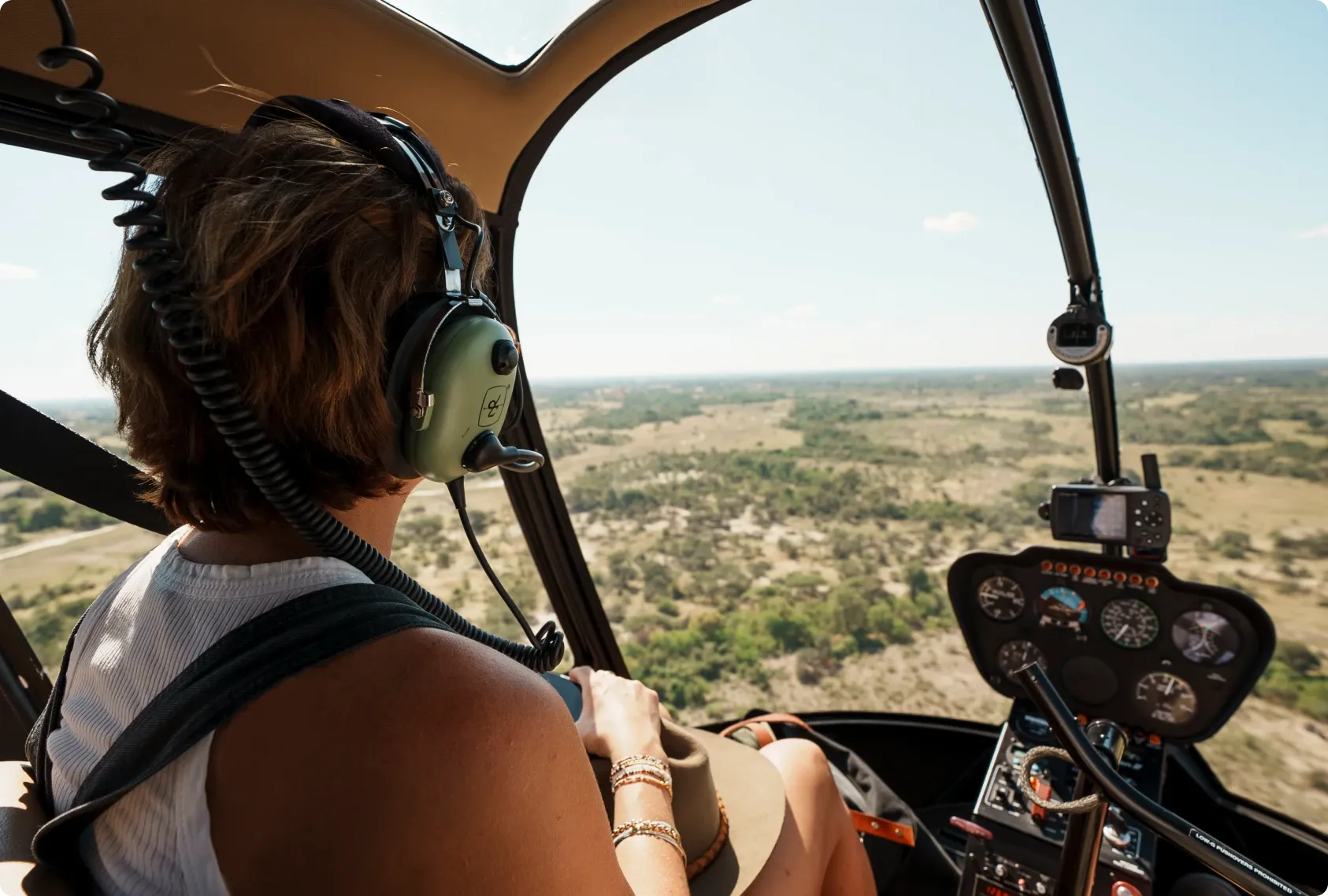 Guest inside a helicopter over the Okavango Delta, enjoying aerial views of Daunara Safari Camp and surrounding waterways.