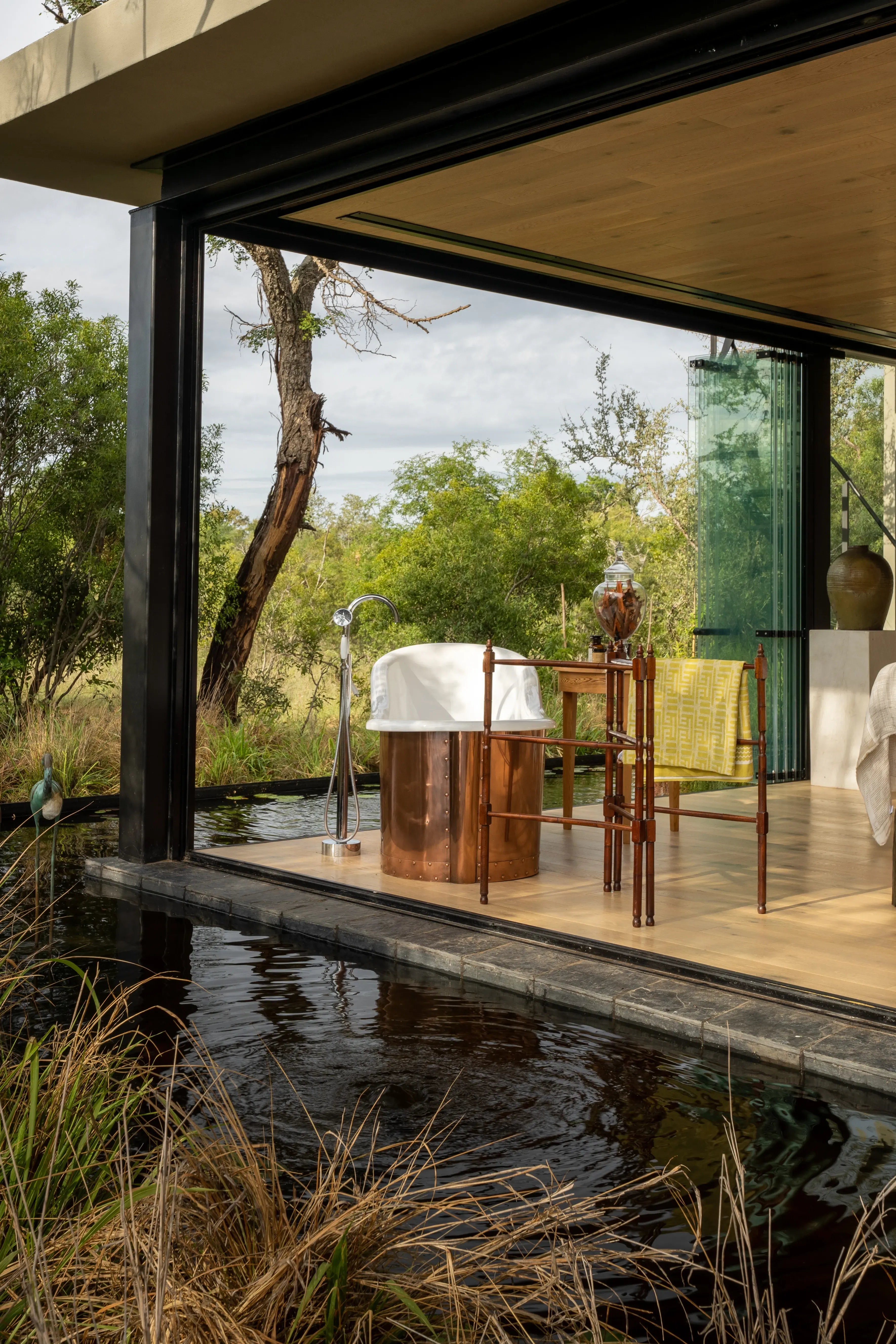 Tranquil spa setting at Monwana with a massage table beside a pond.