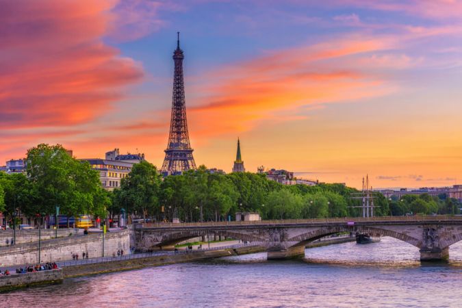 Picture shows sunset over the Seine river in Paris, the Eifel tower in the background.