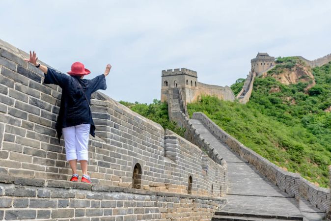 Picture shows an older woman enjoying a stroll along the Great Wall of China.