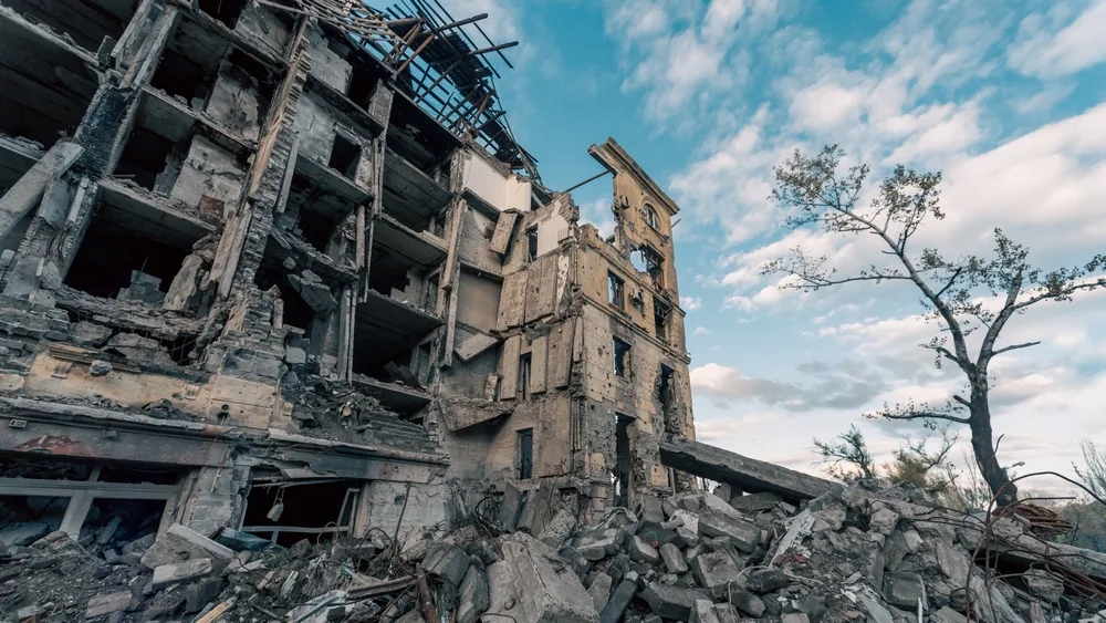 Rubble and damaged building from conflict zone, showing effects of war on infrastructure