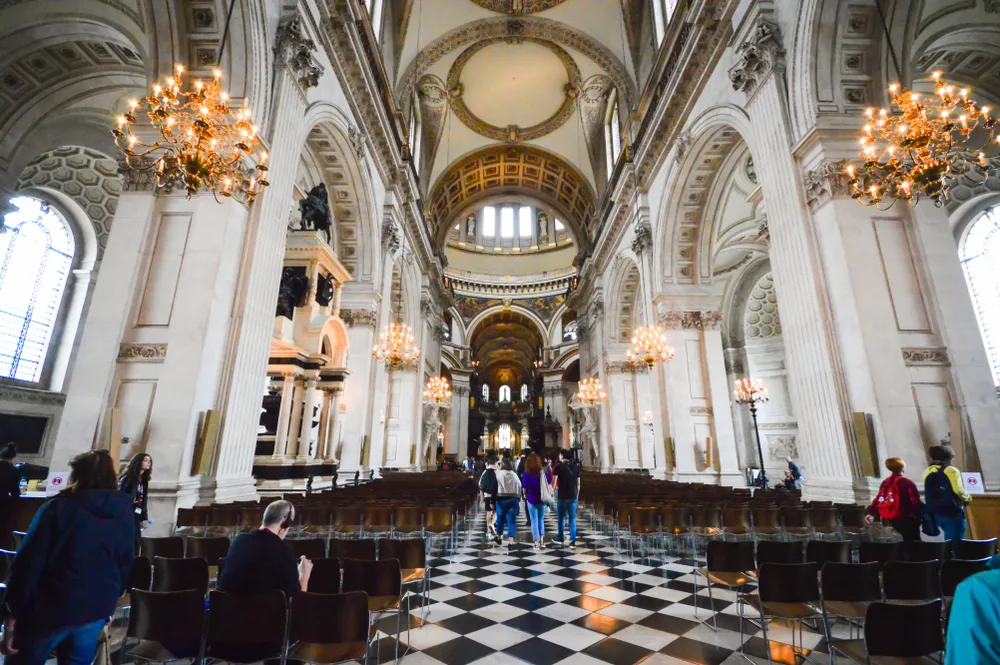 St Paul’s Cathedral interior in London, featuring its grand nave, ornate dome, chandeliers and black-and-white marble floor.
