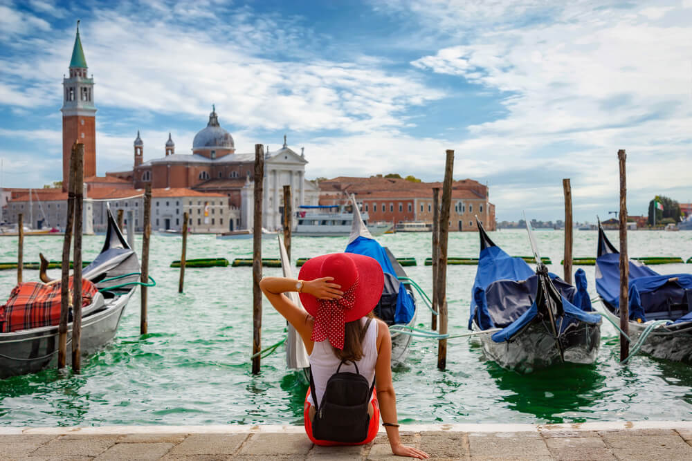 The picture shows a woman enjoying the Grand Canal in Venice, Italy
