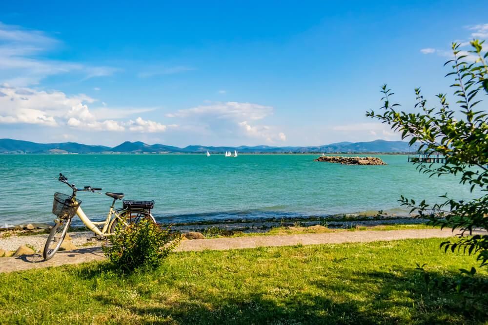 Picture shows a bike at the shoes of a stunning lake in Umbria Italy.