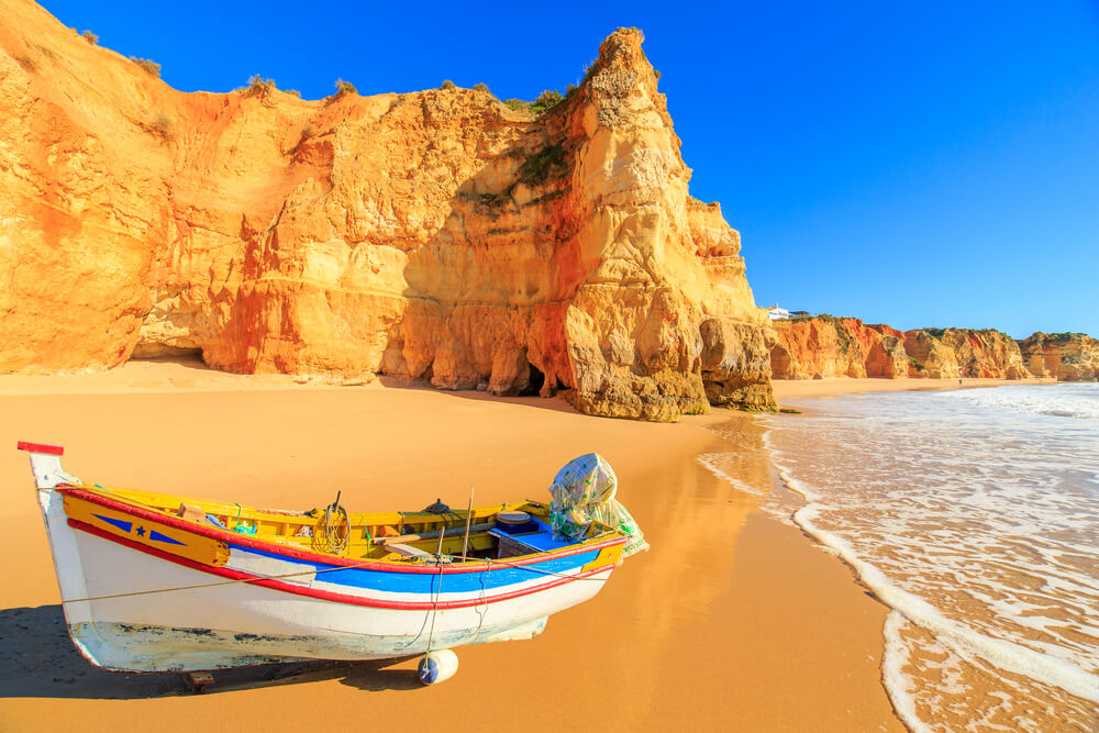 Picture shows a fishing boat on a Praia da Rocha in Portimao, Algarve region, Portugal