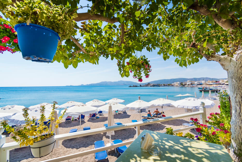 View of Haraki beach from table under tree (Rhodes, Greece)