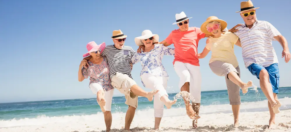 Happy senior friends dancing on the beach