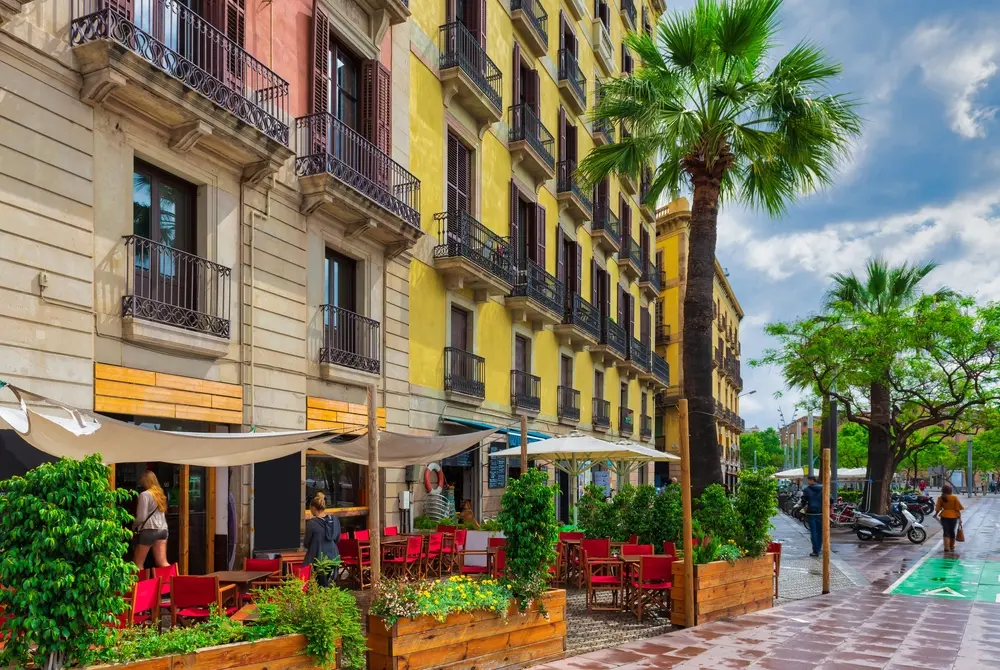 Cozy street with tables of bar in Barcelona.