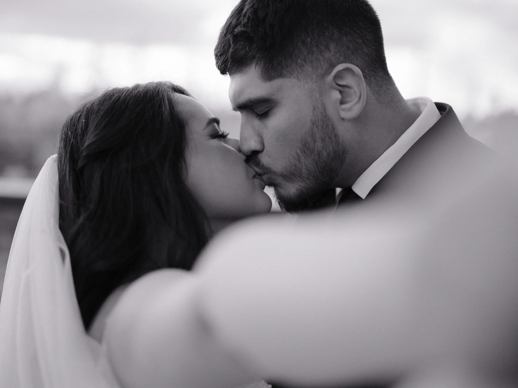 A close kiss — the veil, his hand on her cheek.