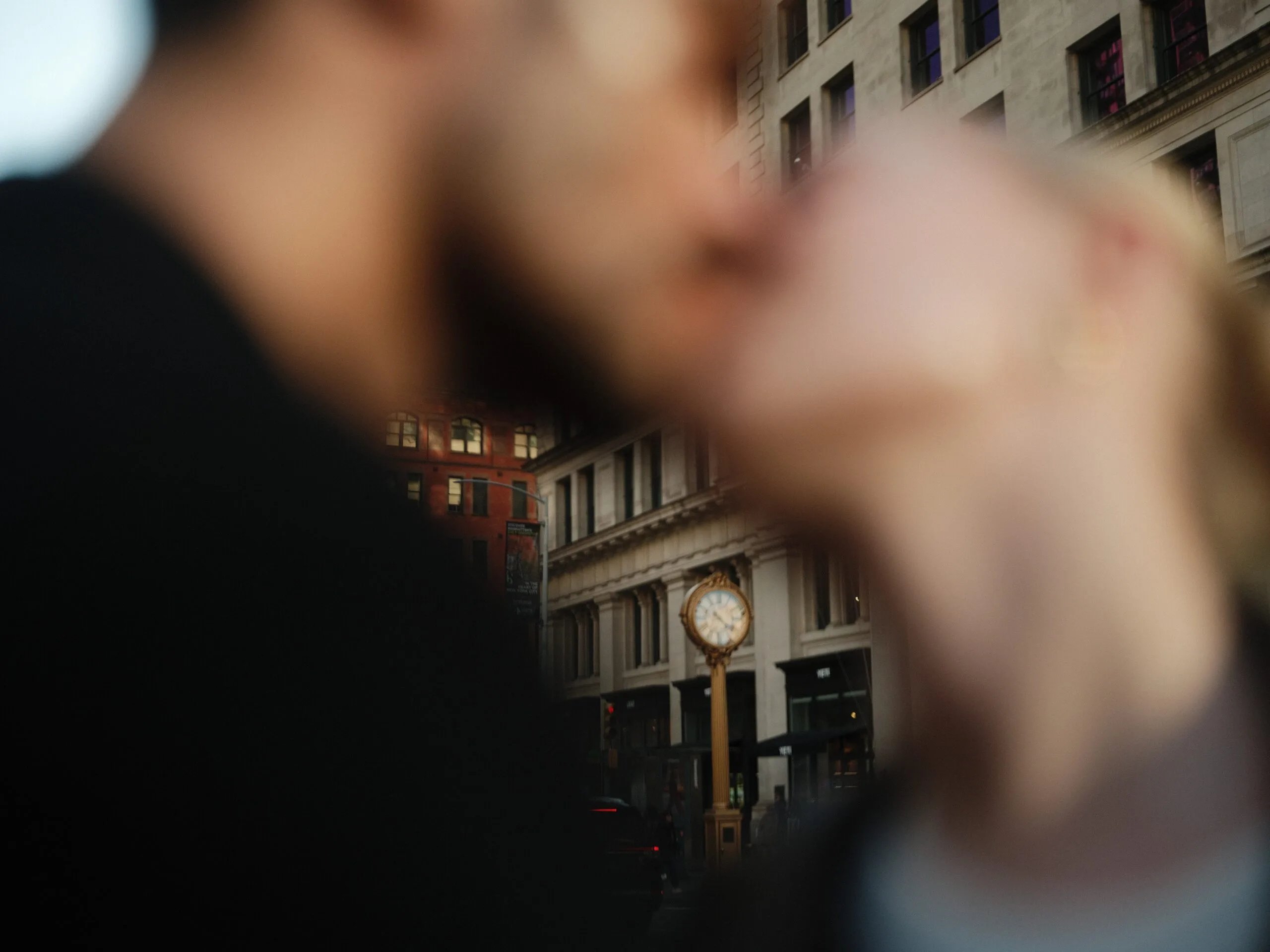 Golden hour — Juan holds Rhylan from behind, the sun low over midtown.