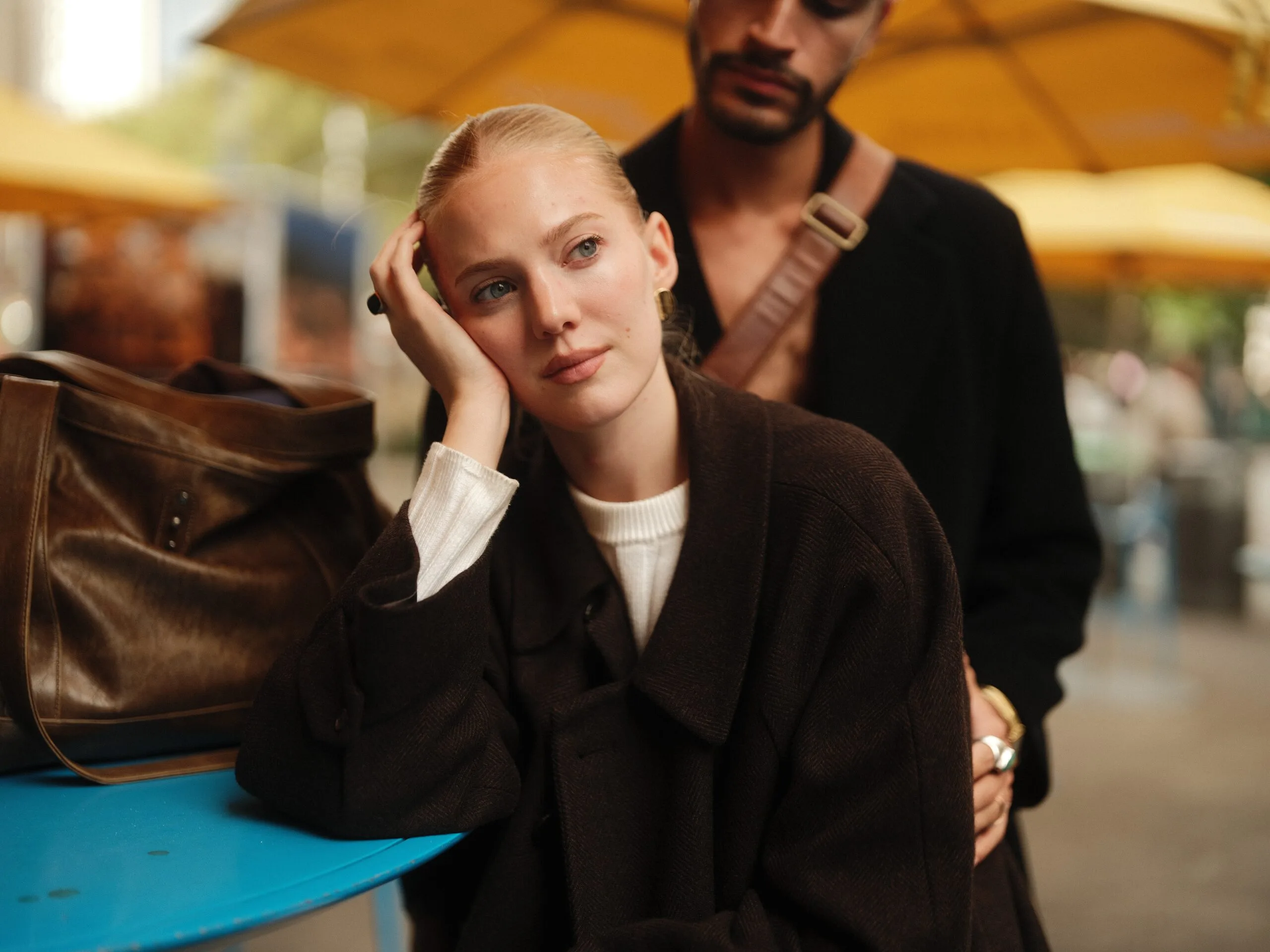 Rhylan rests her head on her hand, Juan visible over her shoulder.