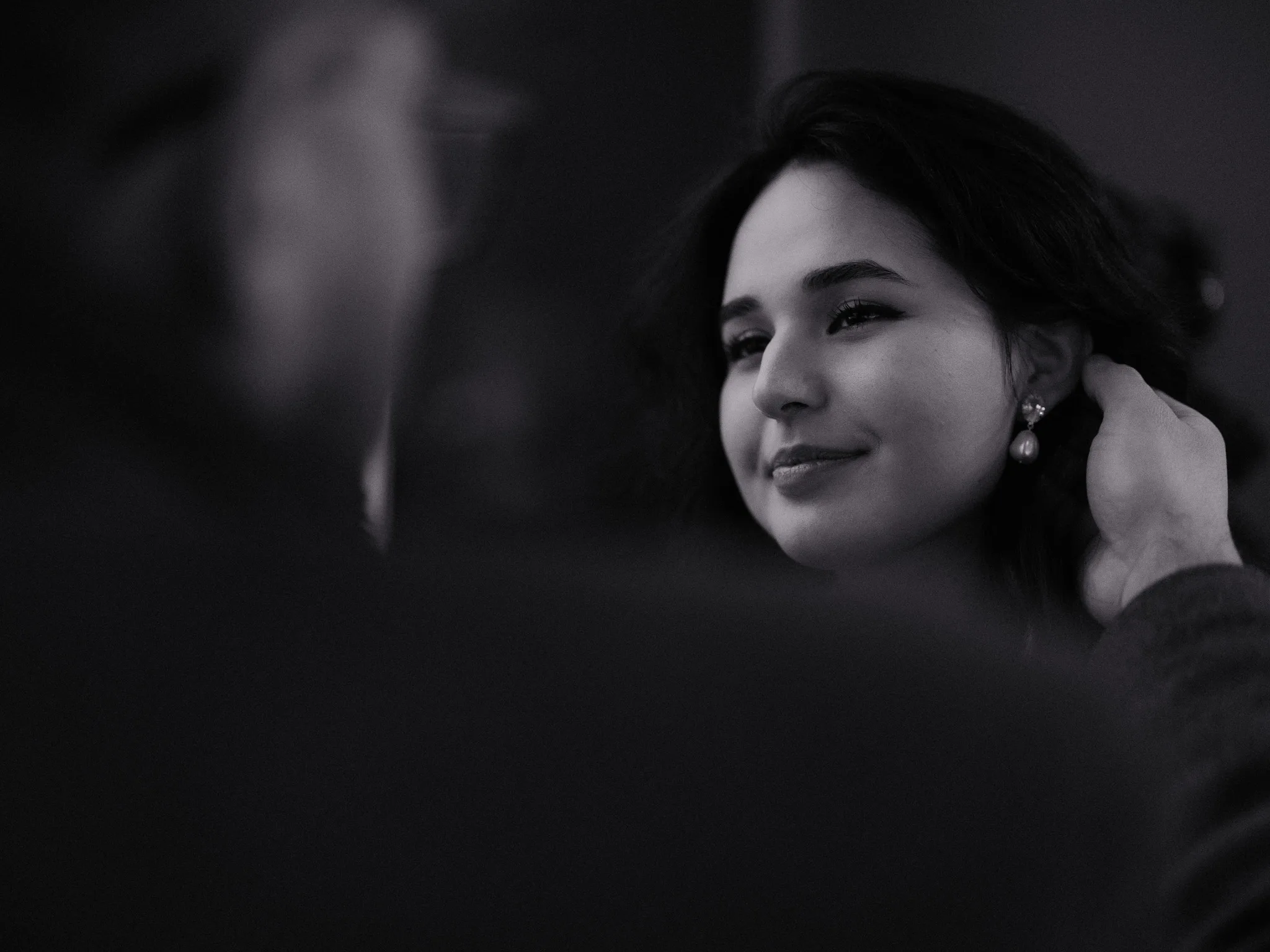 Scarlett at her vanity, putting on a pearl earring, a little half-smile.