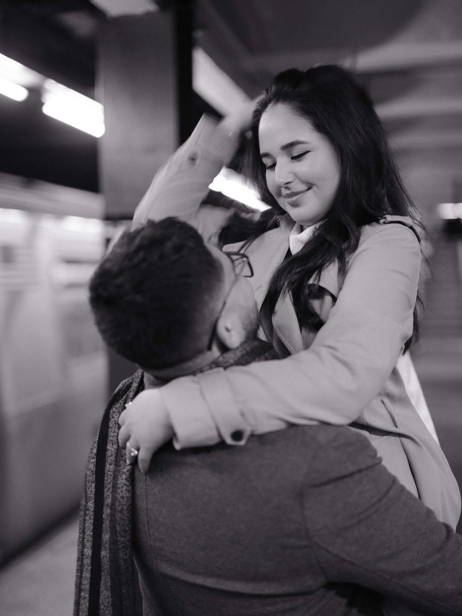 The two of them holding each other on an empty subway platform.