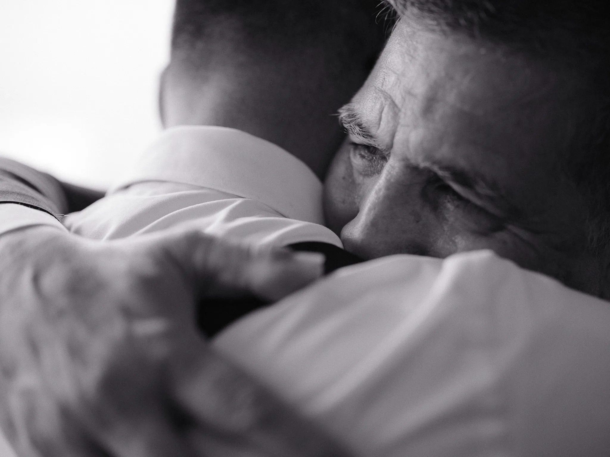 A close, almost wordless embrace — family pressed cheek to shoulder before the day starts.