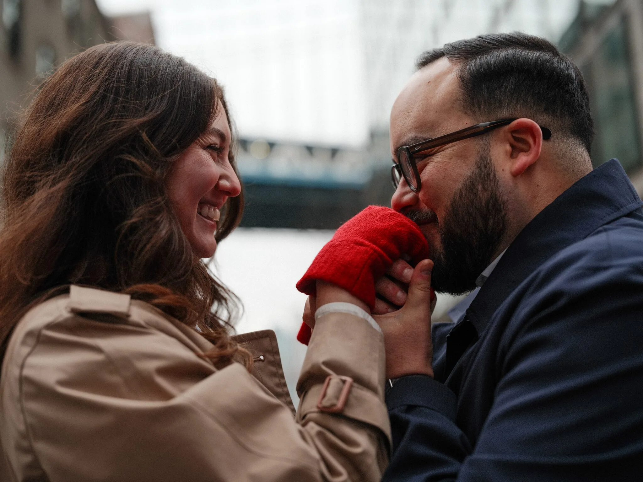 Close — Lexi's red-gloved hand pressed against Alfredo's cheek; he leans in to kiss the glove, both smiling toward each other.