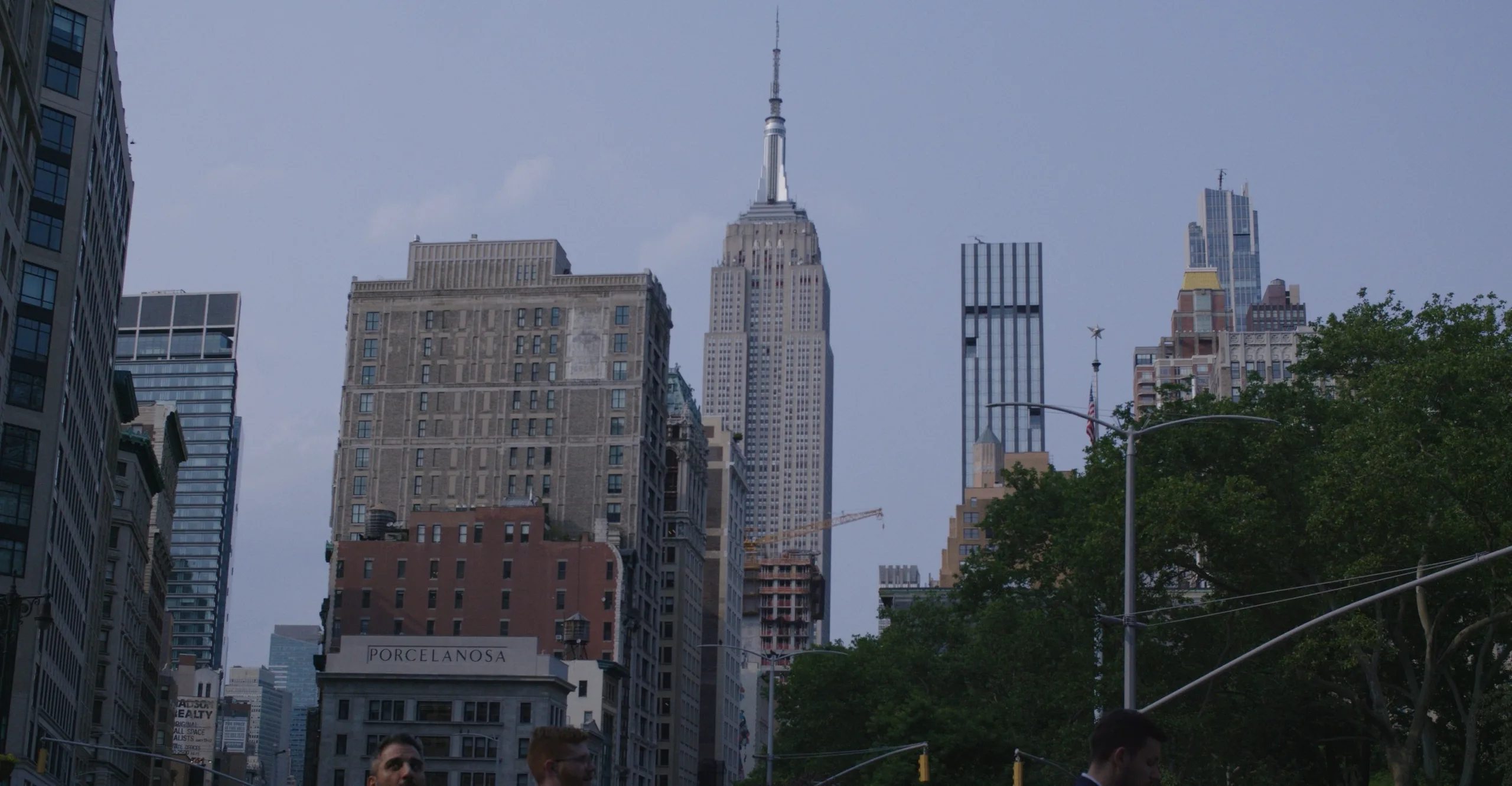 Empire State Building and Manhattan skyline viewed from street level with pedestrians in foreground