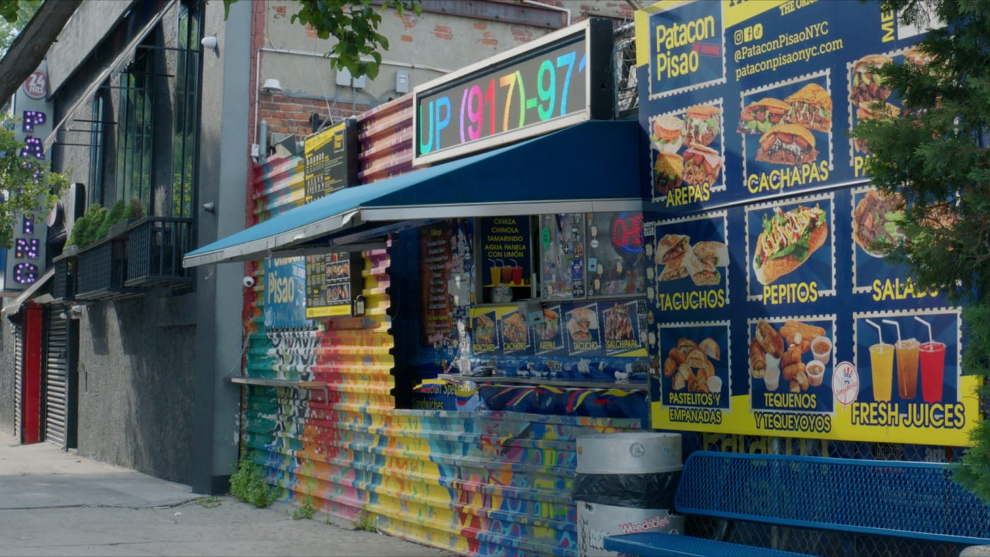 The truck under its neon Patacon Pisao sign on a dark Inwood street