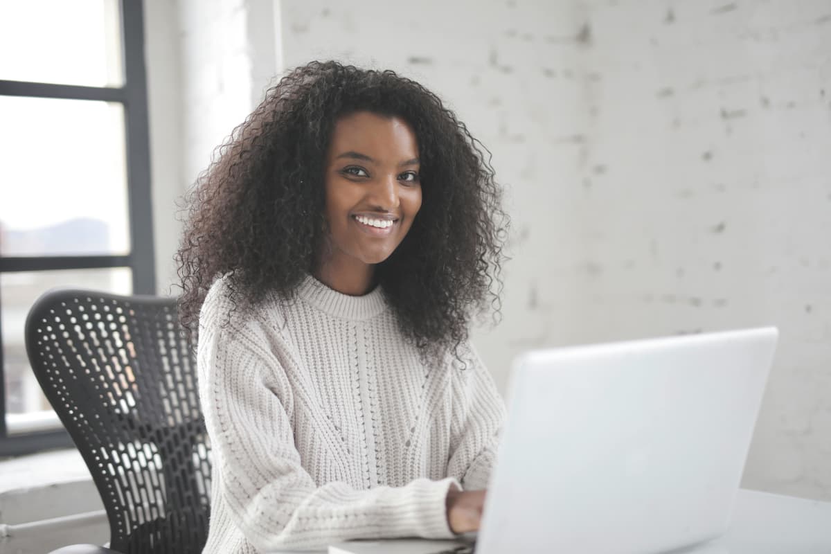 Professional woman in white sweater smiling for corporate headshot
