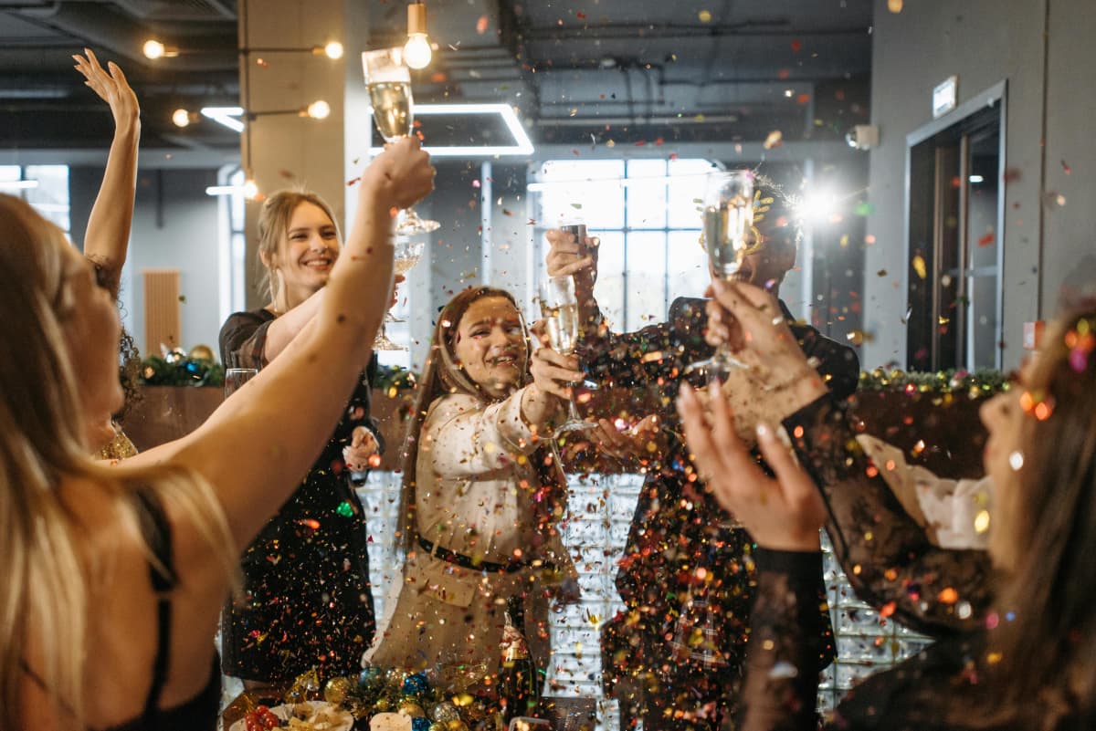 Corporate holiday party with confetti and champagne toast celebration