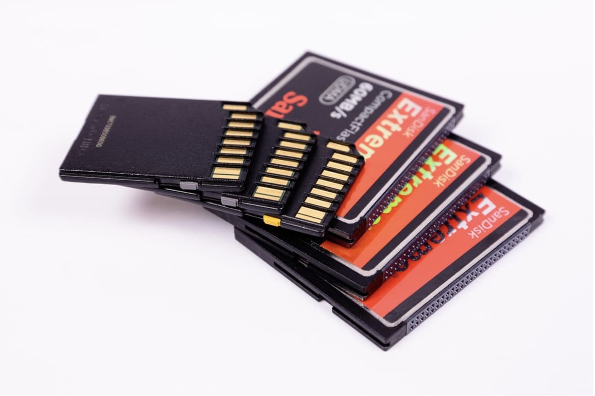 Pile of SD cards from a video shoot — the physical media that lives in the gap between local capture and cloud backup