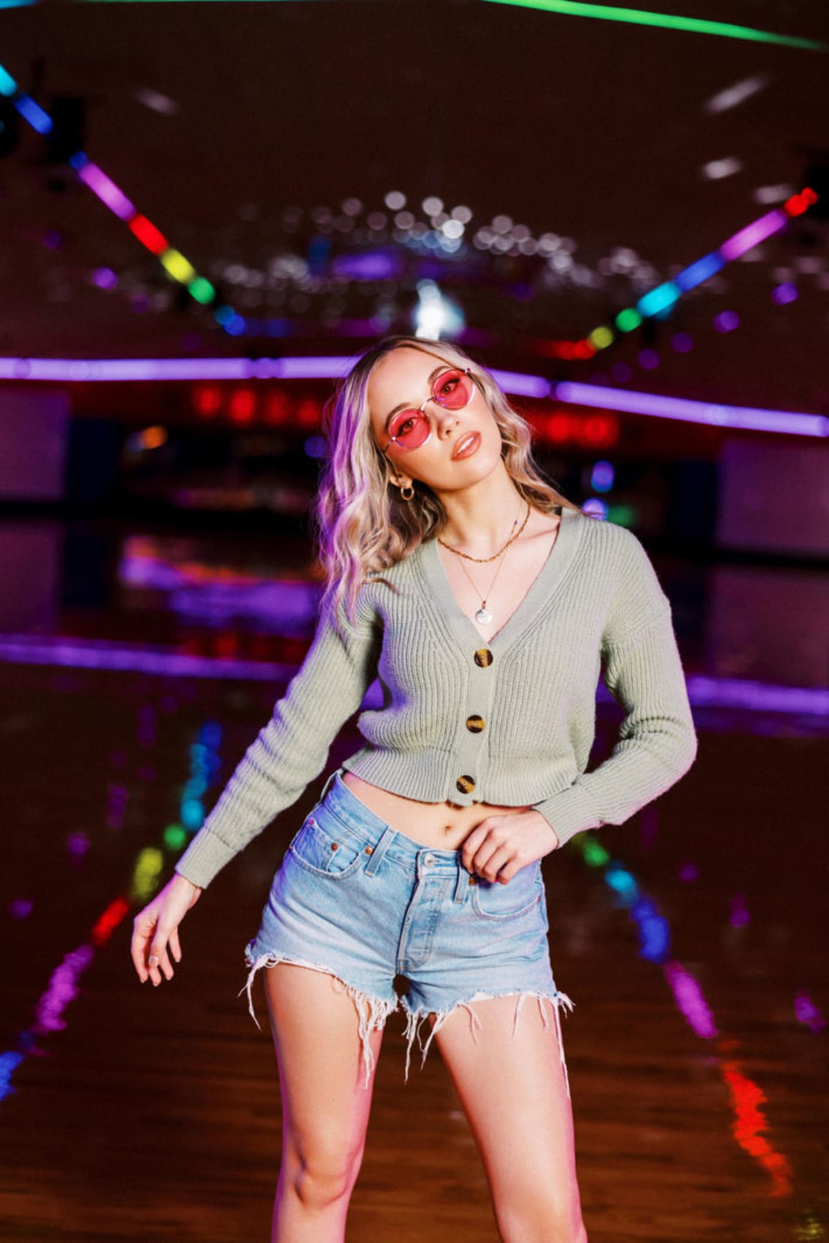 Nightlife fashion portrait with sunglasses and colorful lights