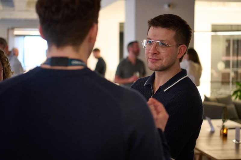 Two professionals networking at an NYC corporate event, one gesturing mid-conversation — Core Visuals event coverage