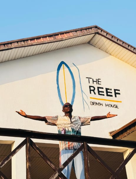 A guest posing with arms outstretched at a beach house