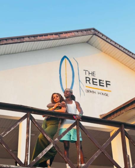 Two friends posing together on a beach-house balcony