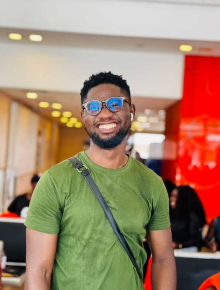 A smiling guest in a green shirt and sunglasses