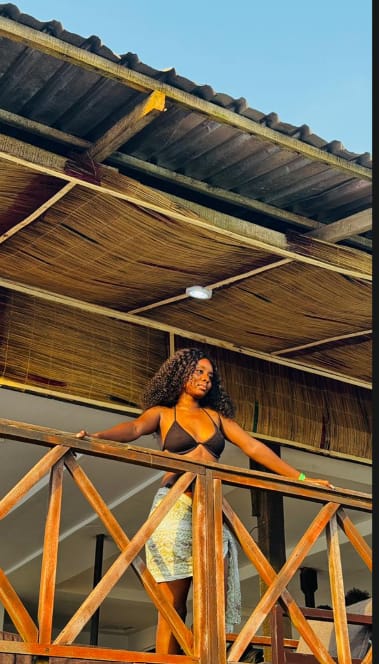 A guest enjoying the view from a beach-house balcony