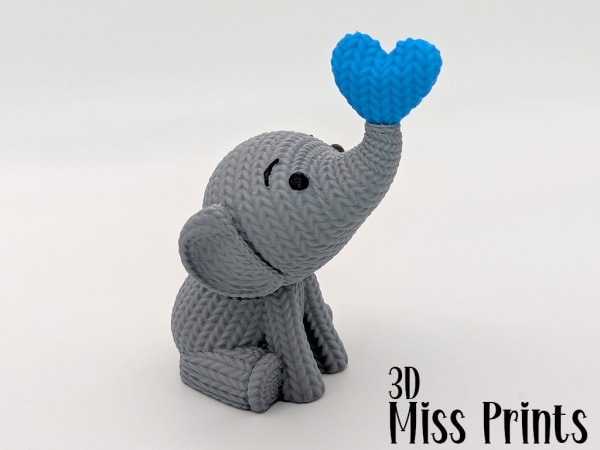 Elefante de punto lanzando un corazón 