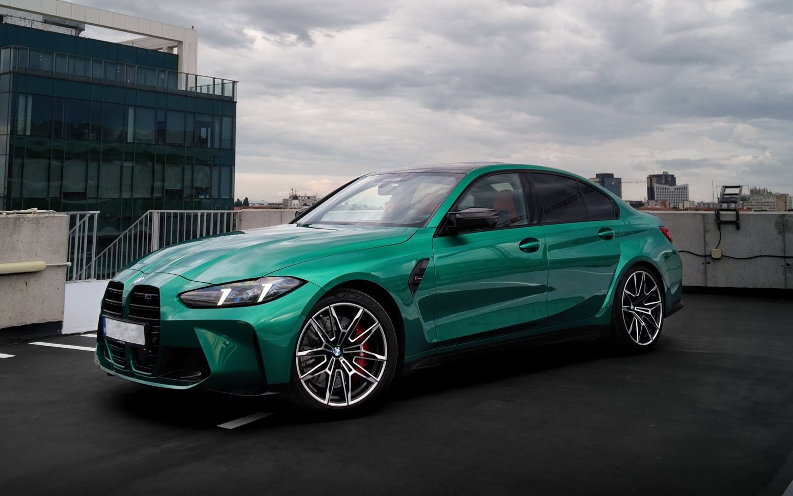 Green BMW M3 E30 in an empty parking structure
