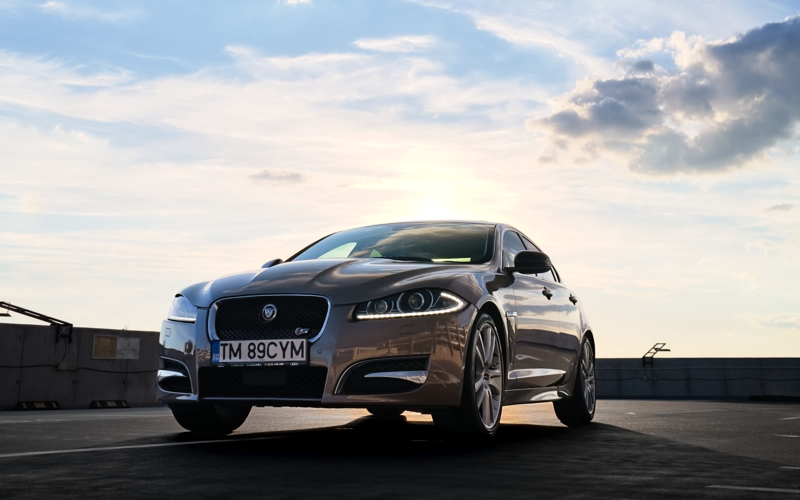 Gray Jaguar XF parked at sunset