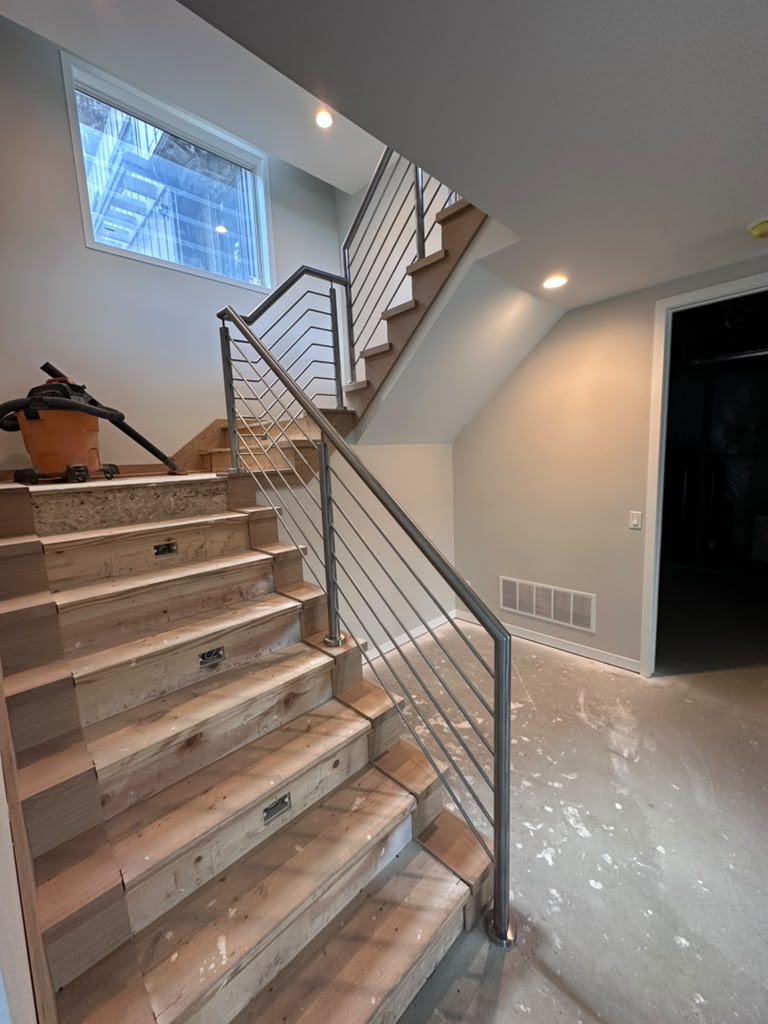 Stainless steel handrail on basement stairs installed during new home construction in Warren, MI