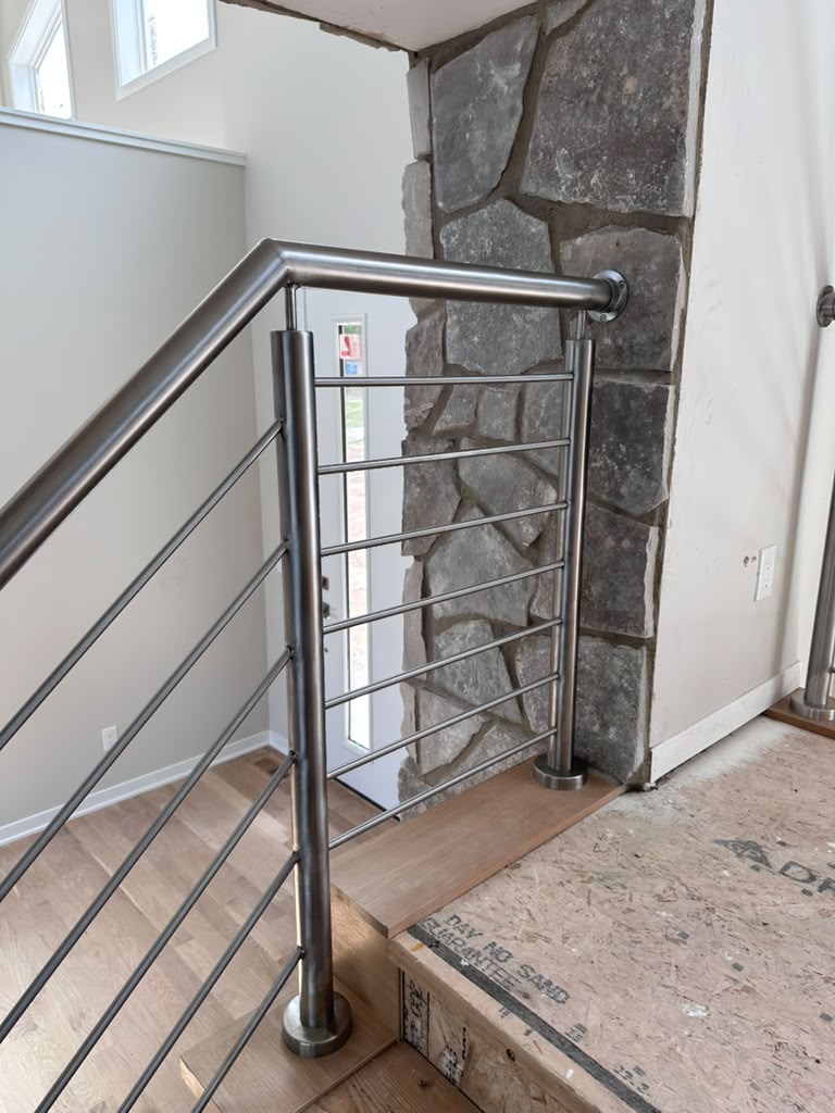 Close-up detail of a brushed stainless steel railing post with horizontal bars, fabricated by Hot Fab Welding in Warren, MI