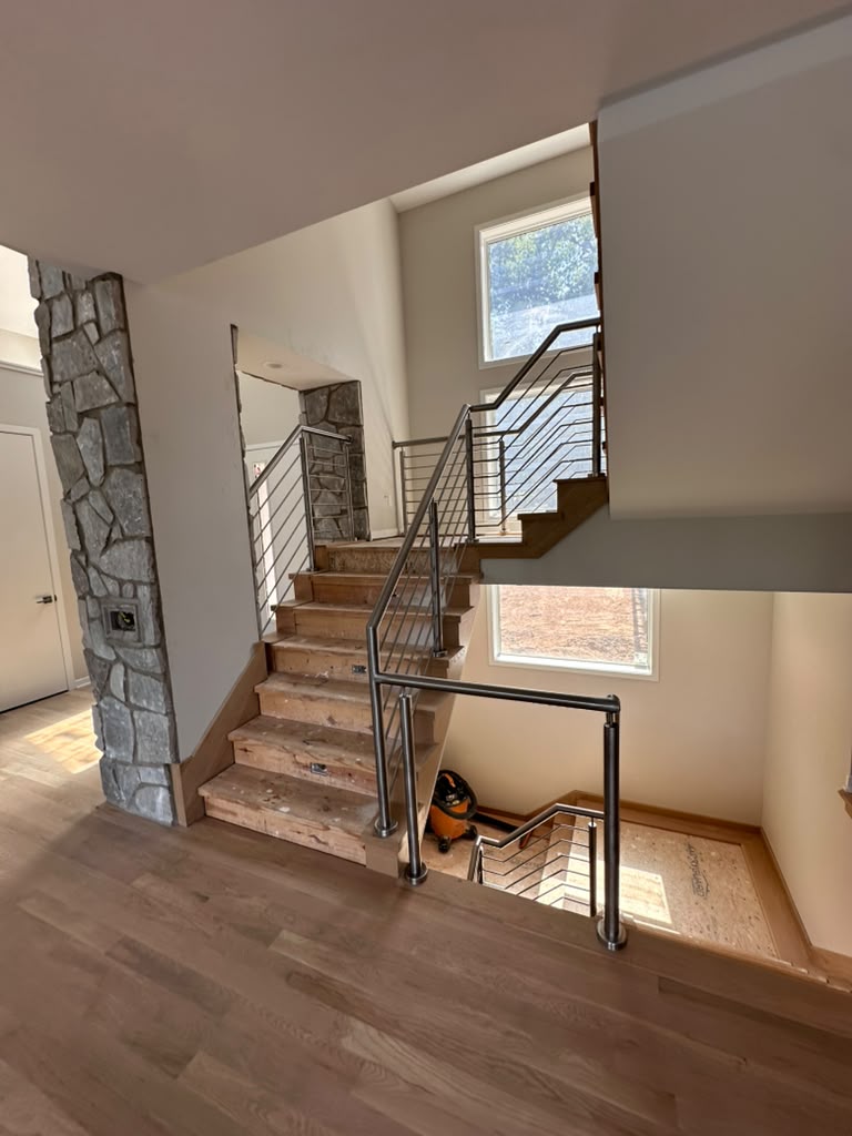 Open concept staircase with modern metal railings fabricated and installed in a Michigan home