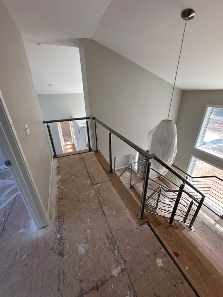 Second floor landing with a custom steel guardrail overlooking the staircase in a Michigan home