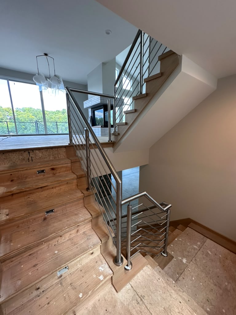 Stainless steel railing on a multi-level staircase, custom fabricated by Hot Fab Welding in Michigan