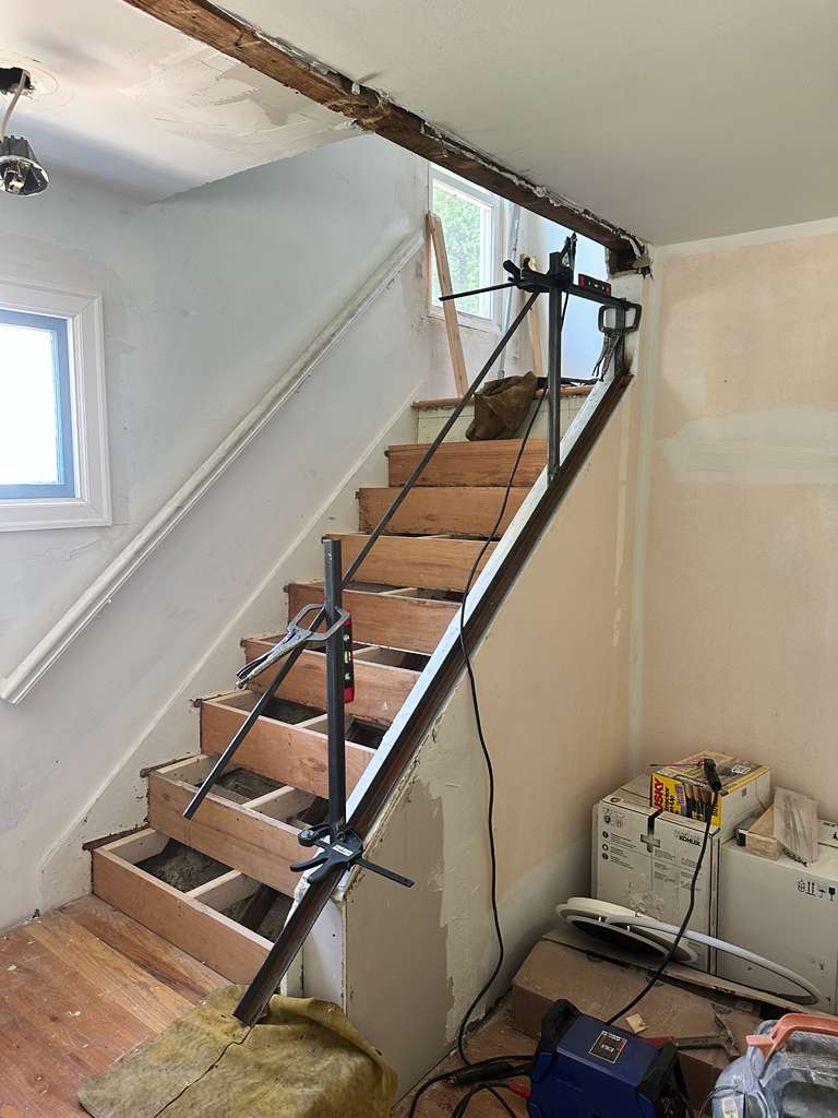 Custom steel stair railing installation in progress by Hot Fab Welding in Warren, MI