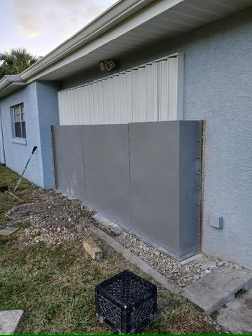 Custom metal storm shield panels fabricated and installed on a home by Hot Fab Welding