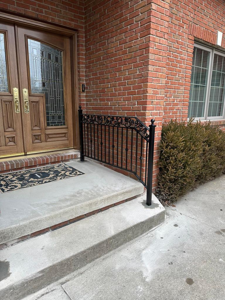 Black wrought iron porch railing installed on a brick home in Warren, MI