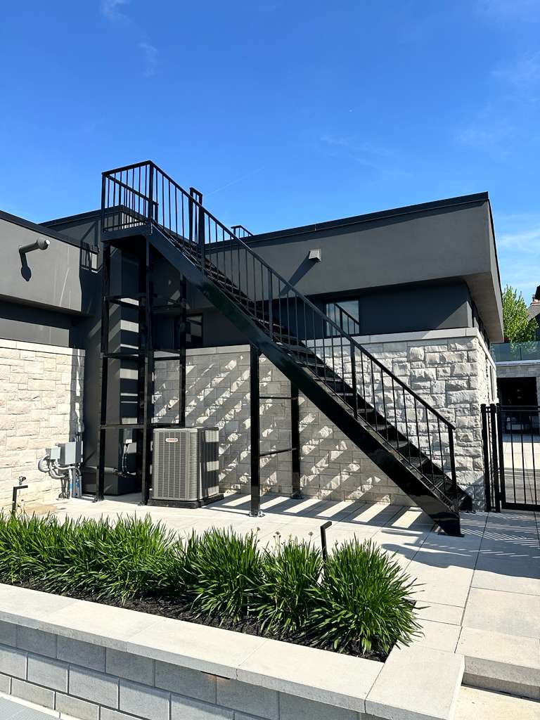 Black steel exterior access staircase on a commercial building, custom fabricated and installed by Hot Fab Welding in Warren, MI