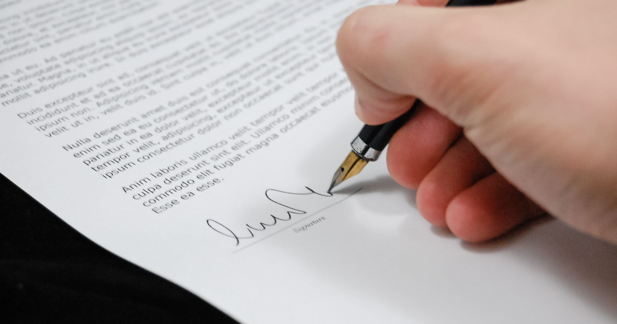 Close-up of a hand signing a personal guarantee document for a Canadian business loan