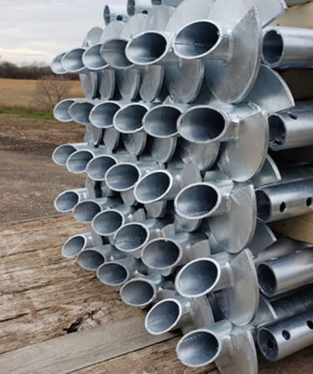 Helical pile components stacked on job site