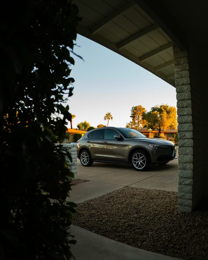 Luxury SUV parked in Arizona driveway at golden hour earning passive income through P2P car rental