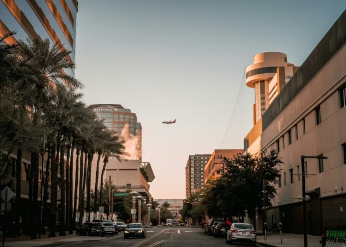 Downtown Phoenix street with plane flying overhead — skip the airport counter with P2P car rental
