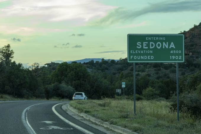 Entering Sedona Arizona highway road sign with green desert landscape