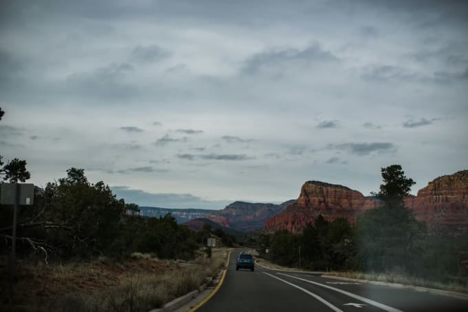 Driving toward Sedona red rock formations on a scenic Arizona highway