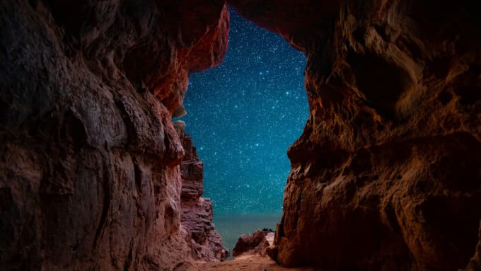 Starry night sky viewed through Sedona red rock cave opening